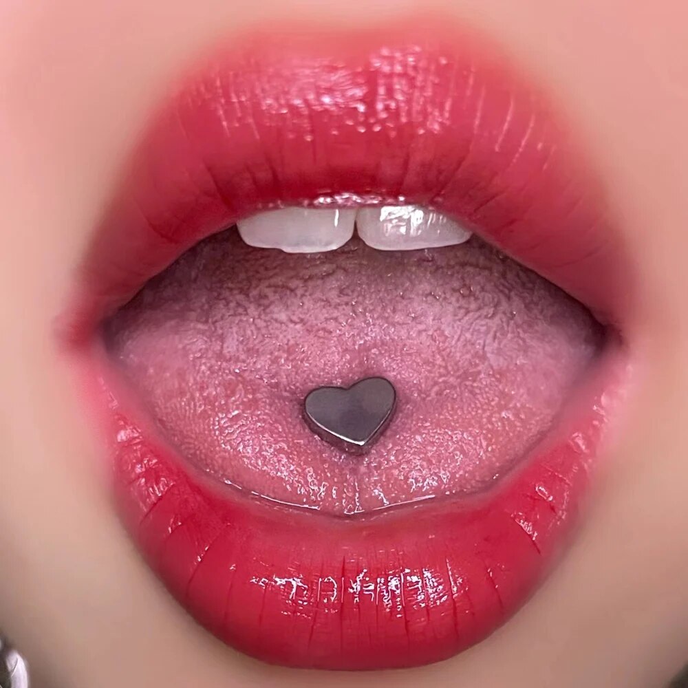 Bouche feminine avec piercing langue en forme de coeur