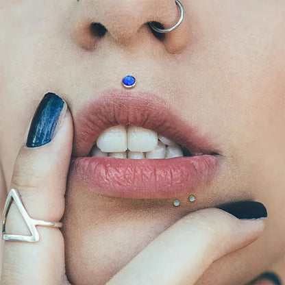 Piercing labret en titane avec pierre bleue, chic et discret sur femme