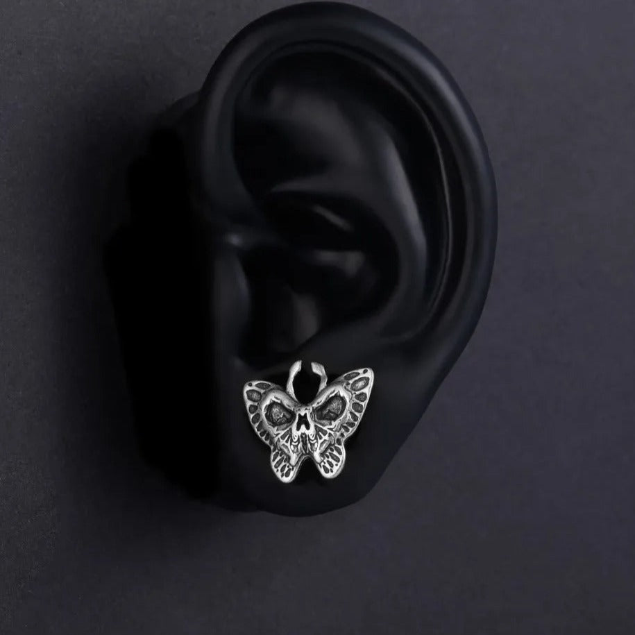 Plugs d'oreilles avec papillon détaillé et motifs macabres.