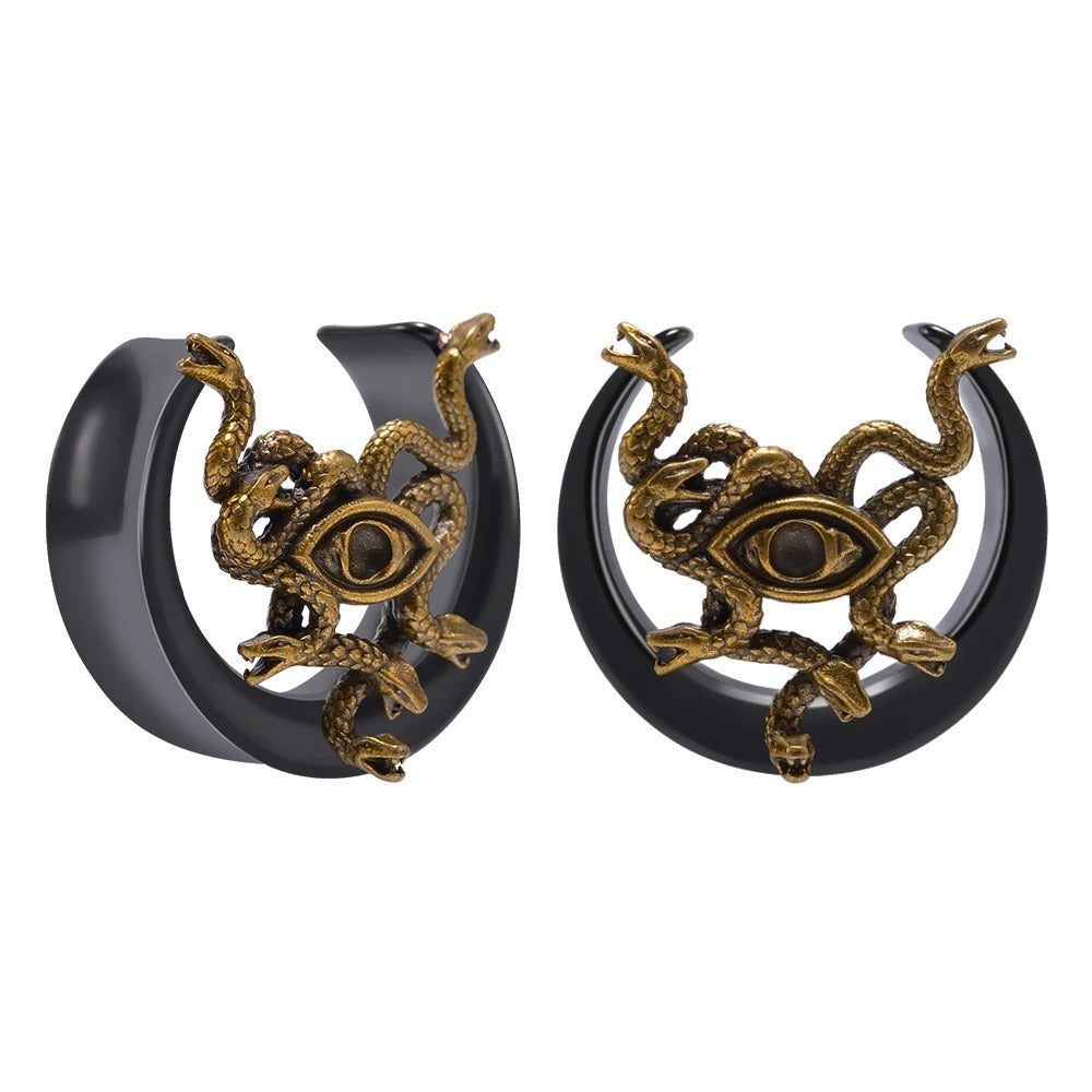 Plug d'oreille serpent et œil, en gros plan sur le design doré.