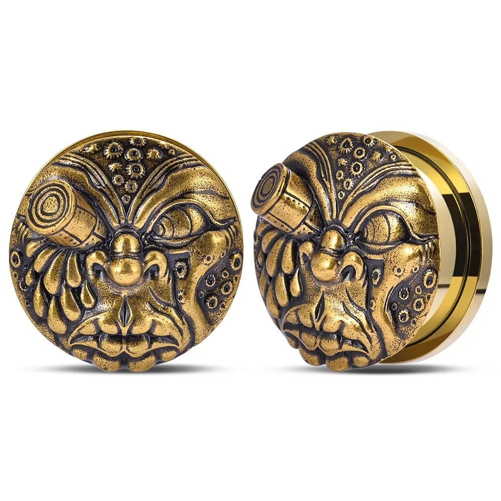 Plugs d'oreilles visage mythique en or.